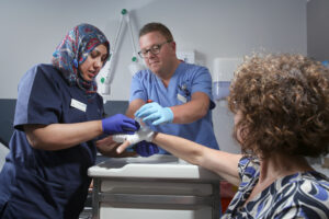 Patient having their hand examined by clinical staff.