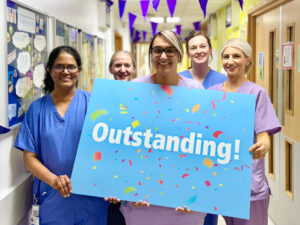 Five members of the Neonatal team holding an Outstanding sign.